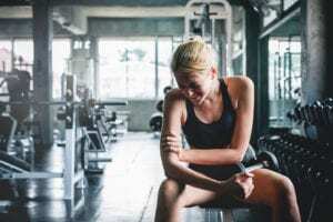 woman in a gym experiencing exercise pain